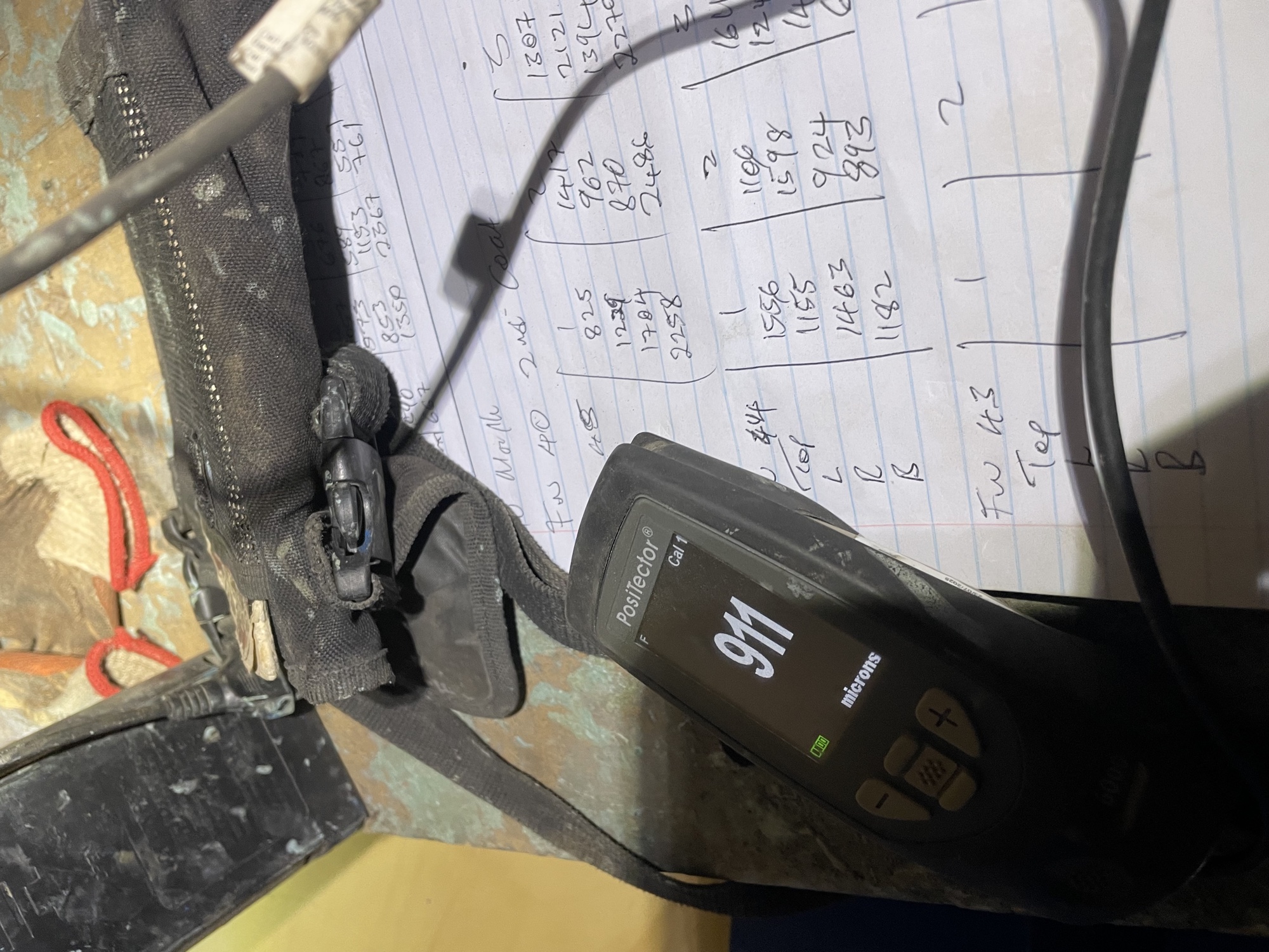 Coating thickness gauge and recorded micron readings used during internal pipe coating inspection
