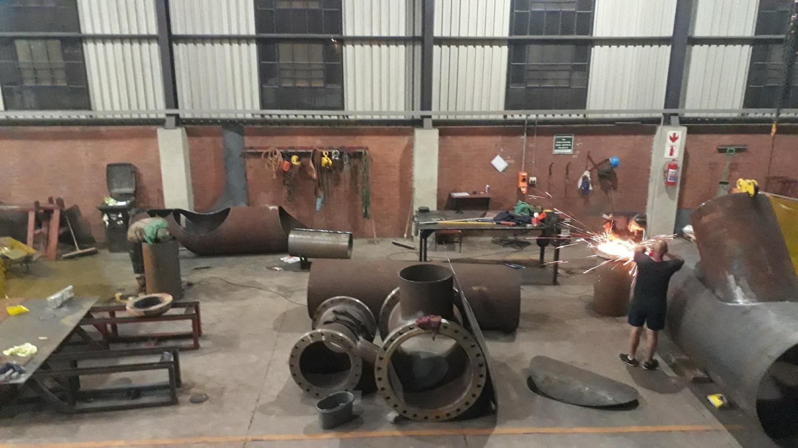 Pipe fittings and fabricated steel sections under construction in a workshop